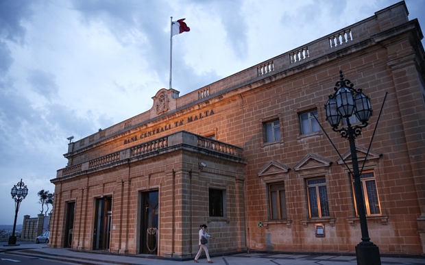 A Maltese national flag flies above the Central Bank of Malta in Valletta, Malta, on Tuesday, Oct. 20, 2015. ECB President Mario Draghi will convene his Governing Council on the Mediterranean island of Malta this week to set monetary policy for a 19-nation region that is seeing its recovery buffeted by slowing international trade and global market volatility. Photographer: Yorgos Karahalis/Bloomberg