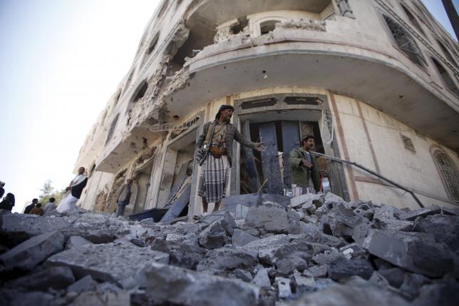 A Houthi militant screams to people to go away while standing on the rubble of a house damaged by a Saudi-led air strike in the neighbourhood of Al-Garda at Shomila area in Yemen's capital Sanaa, November 29, 2015. REUTERS/Mohamed al-Sayaghi
